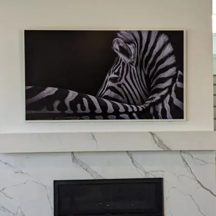 Samsung Frame TV professionally installed above marble fireplace.