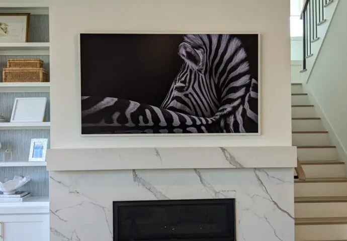 Samsung Frame TV professionally installed above marble fireplace.