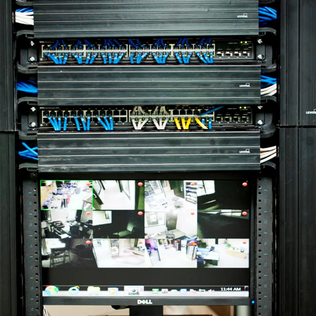 Corporate office AV rack with cabling and surveillance monitor.