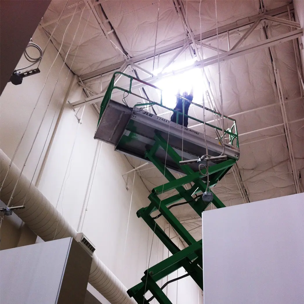 Industrial warehouse electronics installation on lift.