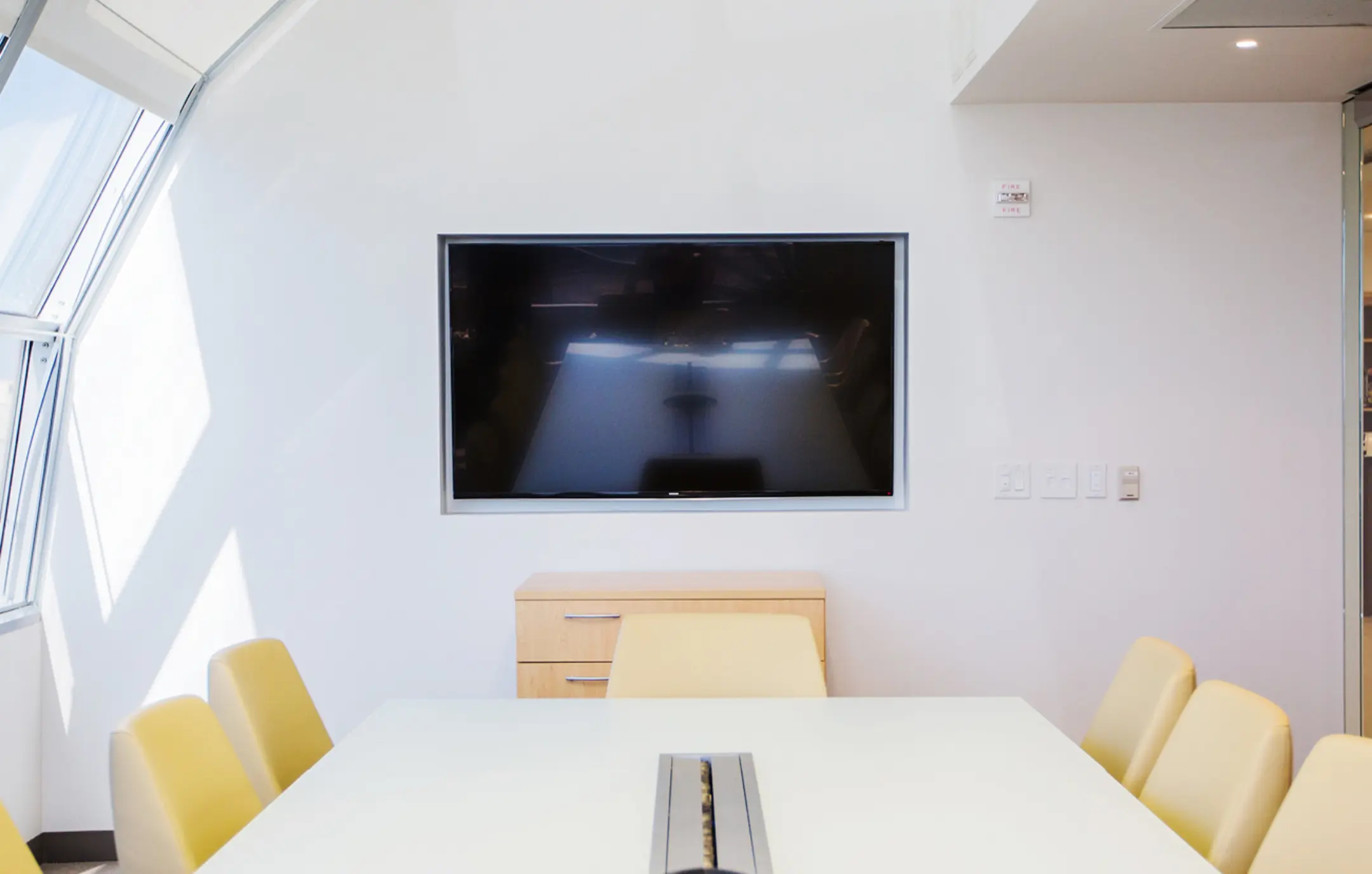 Conference room in office with installed television screen over table.