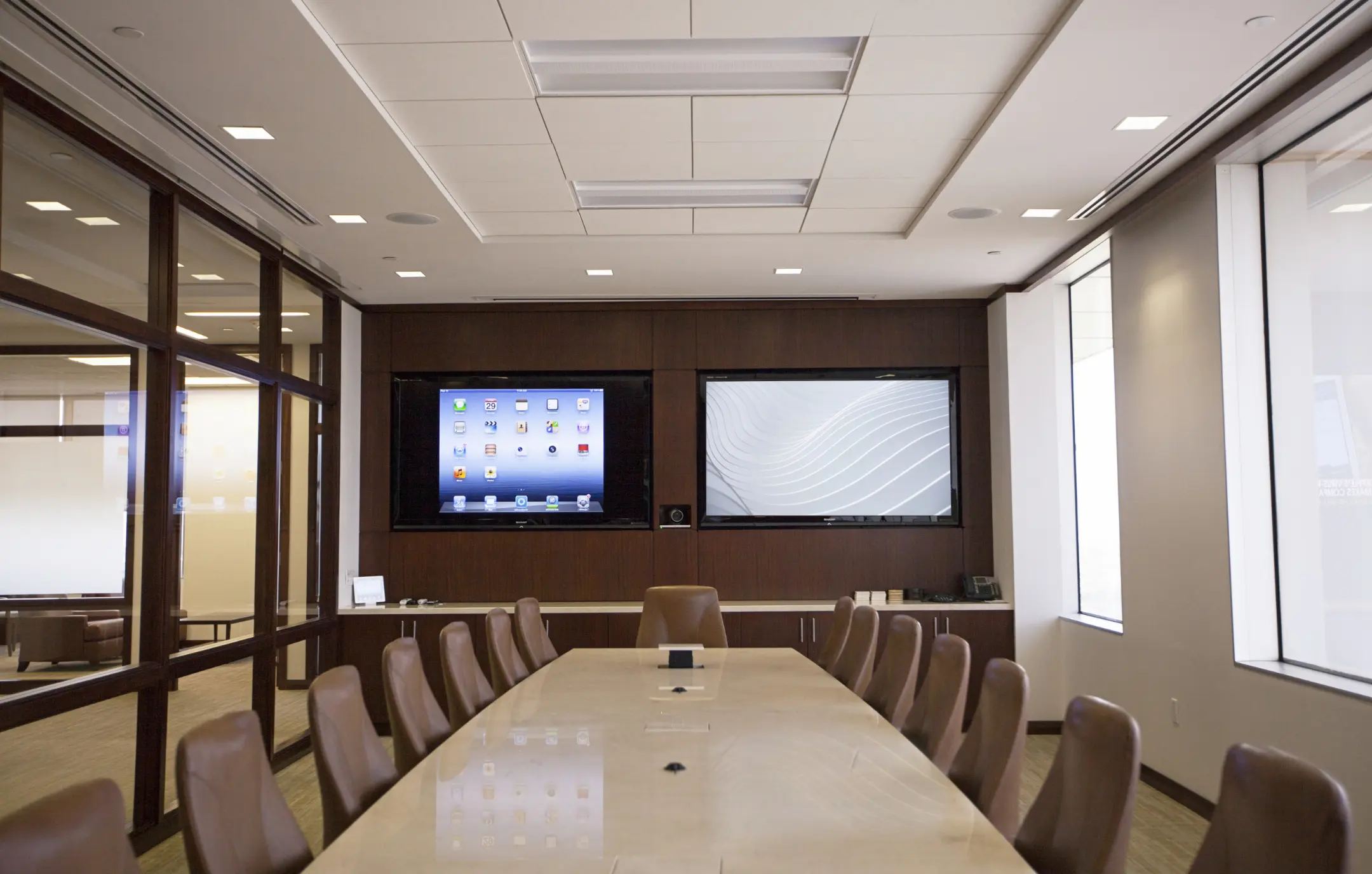 Dual screen AV installation with web camera in corporate office board room.