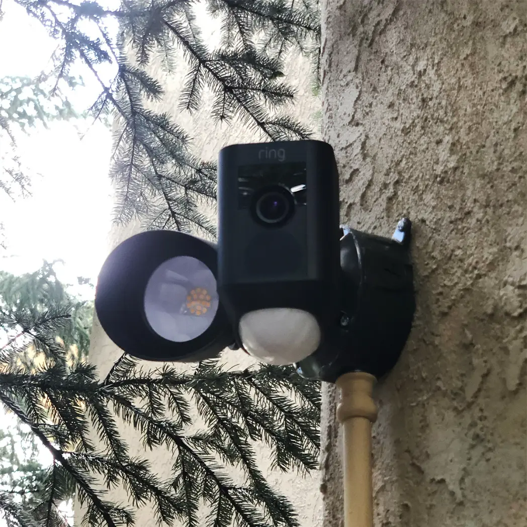 Outdoor home security surveillance camera and floodlight.