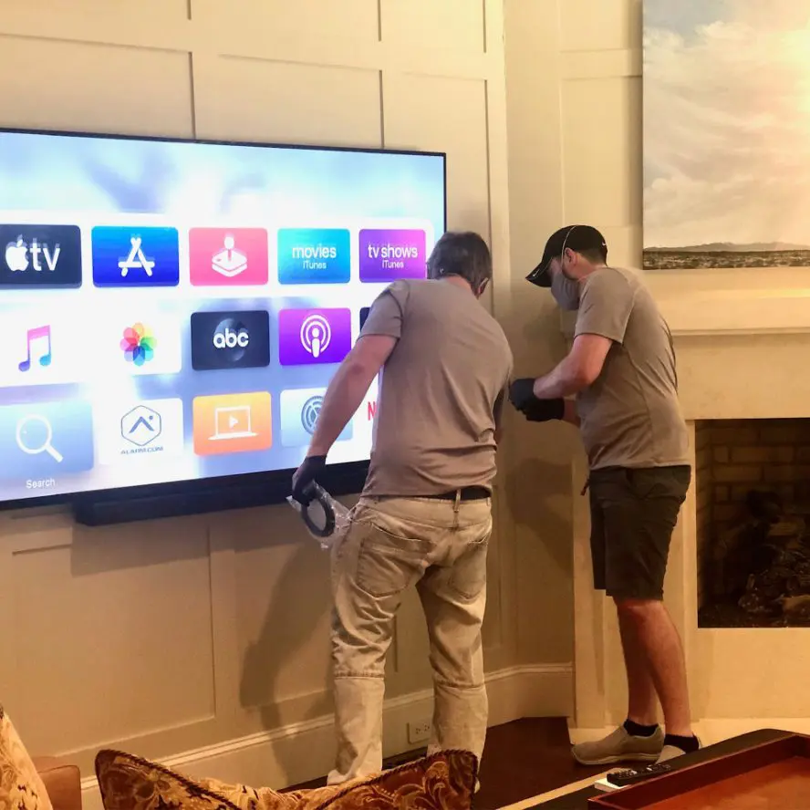 IQueue Media professionals finishing a TV installation in home.