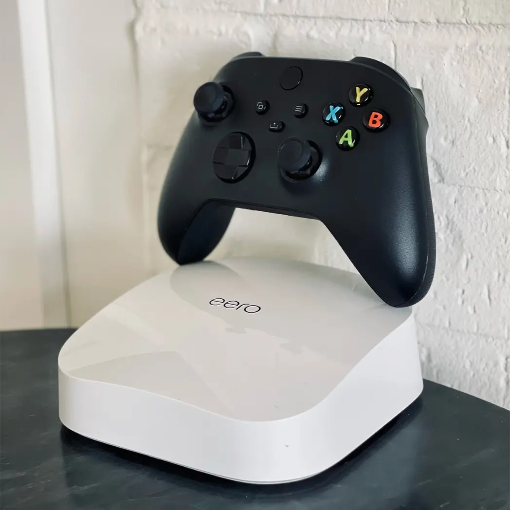 Eero WiFi extender and gaming remote in home.
