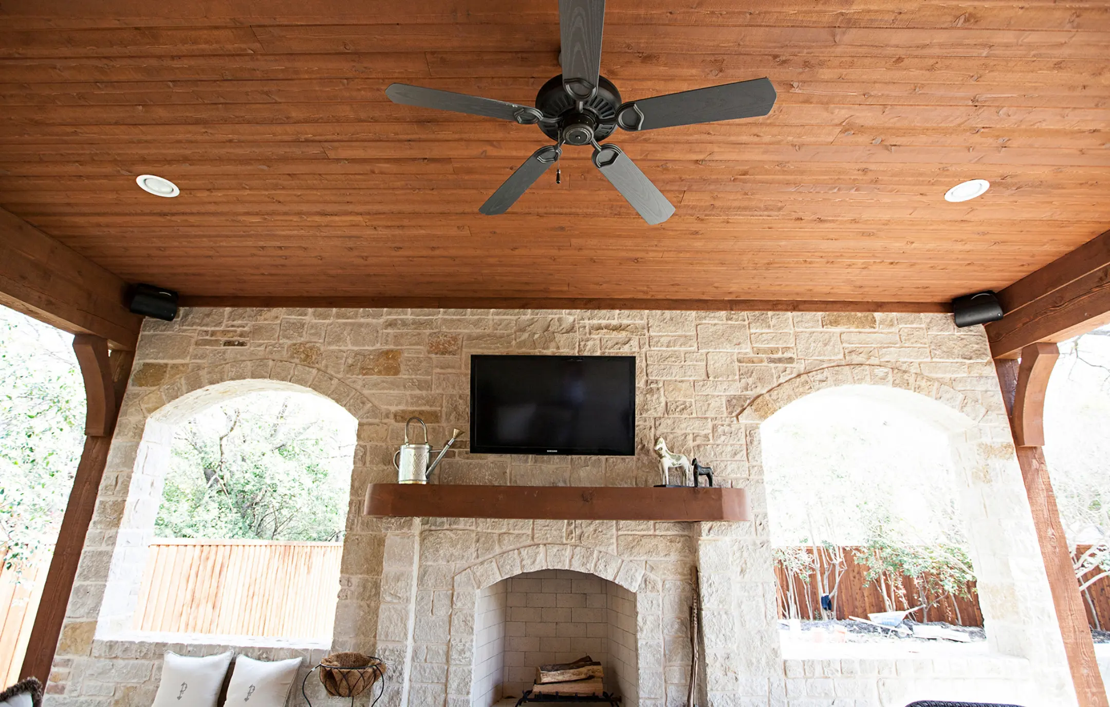 Outdoor living area with A/V installation above fireplace.