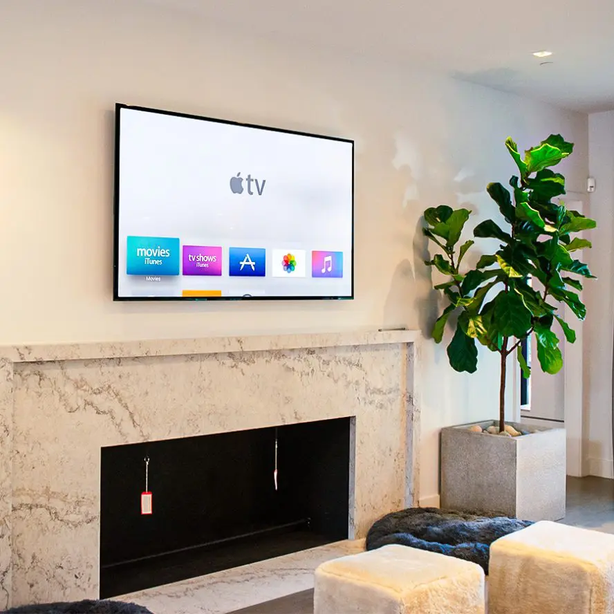 TV installation with Apple TV above marble fireplace. 