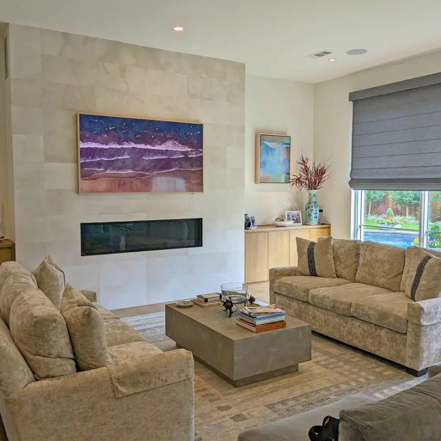 Samsung Frame TV installed above fireplace on modern stone wall. 