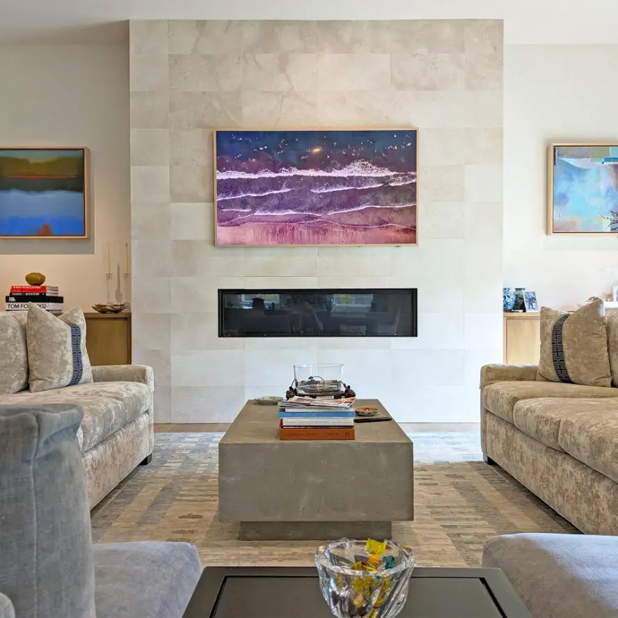 Samsung Frame TV installed above fireplace on modern stone wall. 