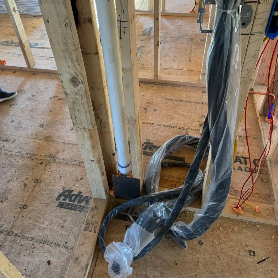 Network cabling in new home construction framing with plastic tubing.