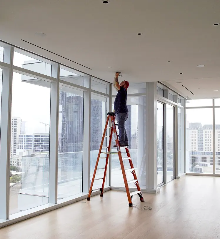 Pre-wiring and network work from a ladder by a professional installer in high-rise condo in Uptown Dallas. 